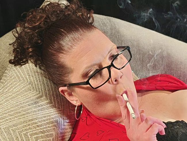 Download: hersmokey - Sie sitzt in einem roten Morgenmantel und schwarzem BH, raucht und neckt.